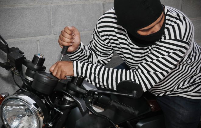 Example of a motorcycle being stolen. (Shutterstock.com/chalermphon_tiam)